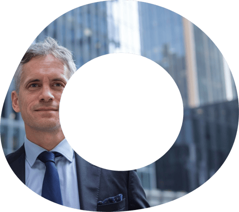 Uomo con capelli bianchi in giacca e cravatta davanti a grattacieli