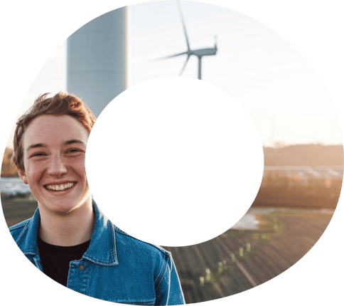 Ragazzo giovane che sorride con dietro delle pale eoliche Ragazzo giovane che sorride con dietro delle pale eoliche